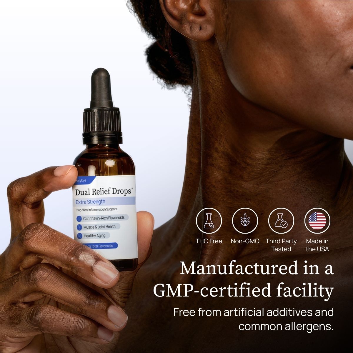 A person holds a bottle of Dual Relief™ Drops against a clean white background, with close-up side of the person's neck and jawline visible. Text on the right reads 'Manufactured in a GMP-certified facility' and includes icons for THC free, non-GMO, third party tested, and made in the USA.